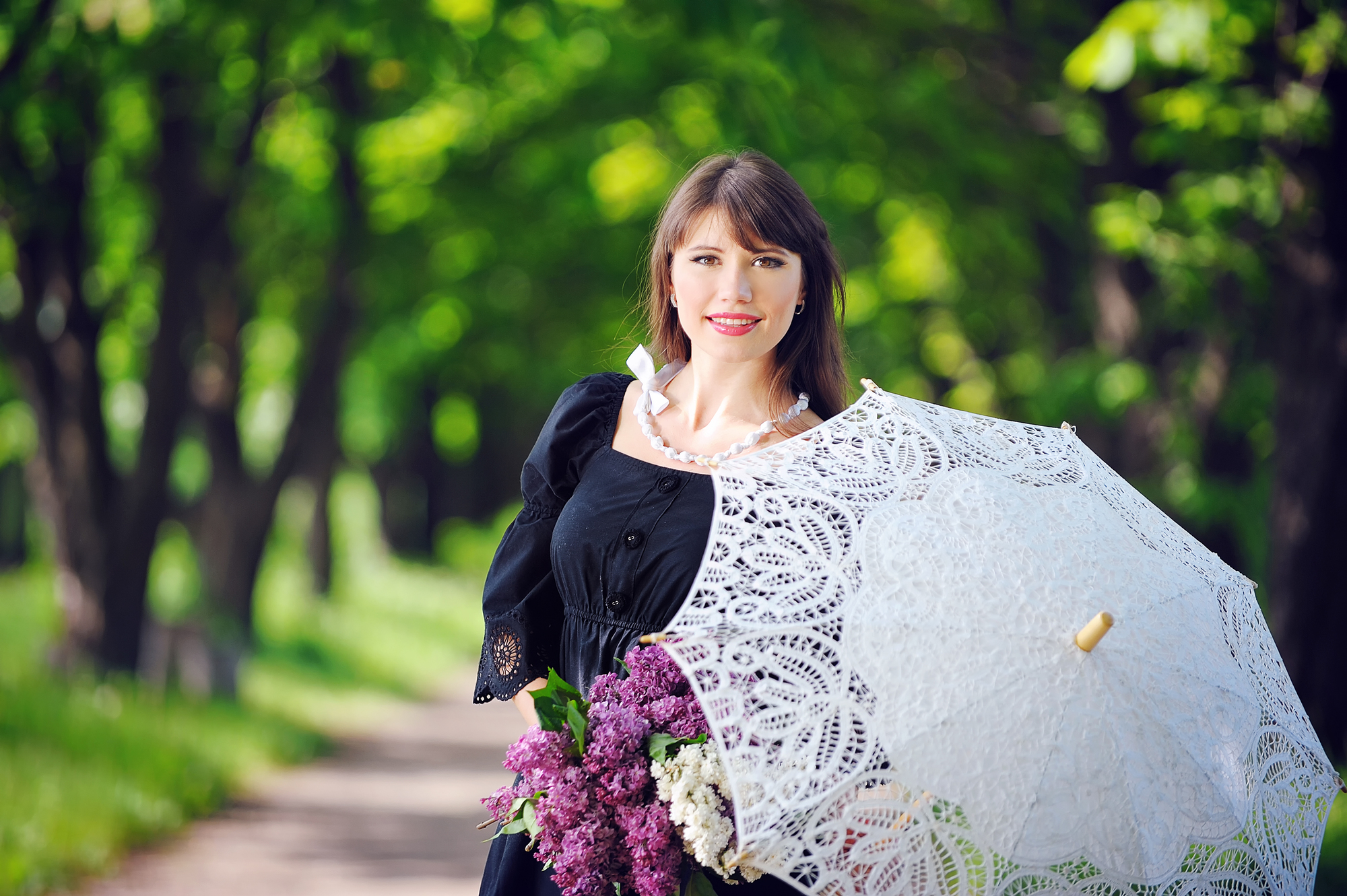 portrait of a young woman in a spring park with an umbrella.