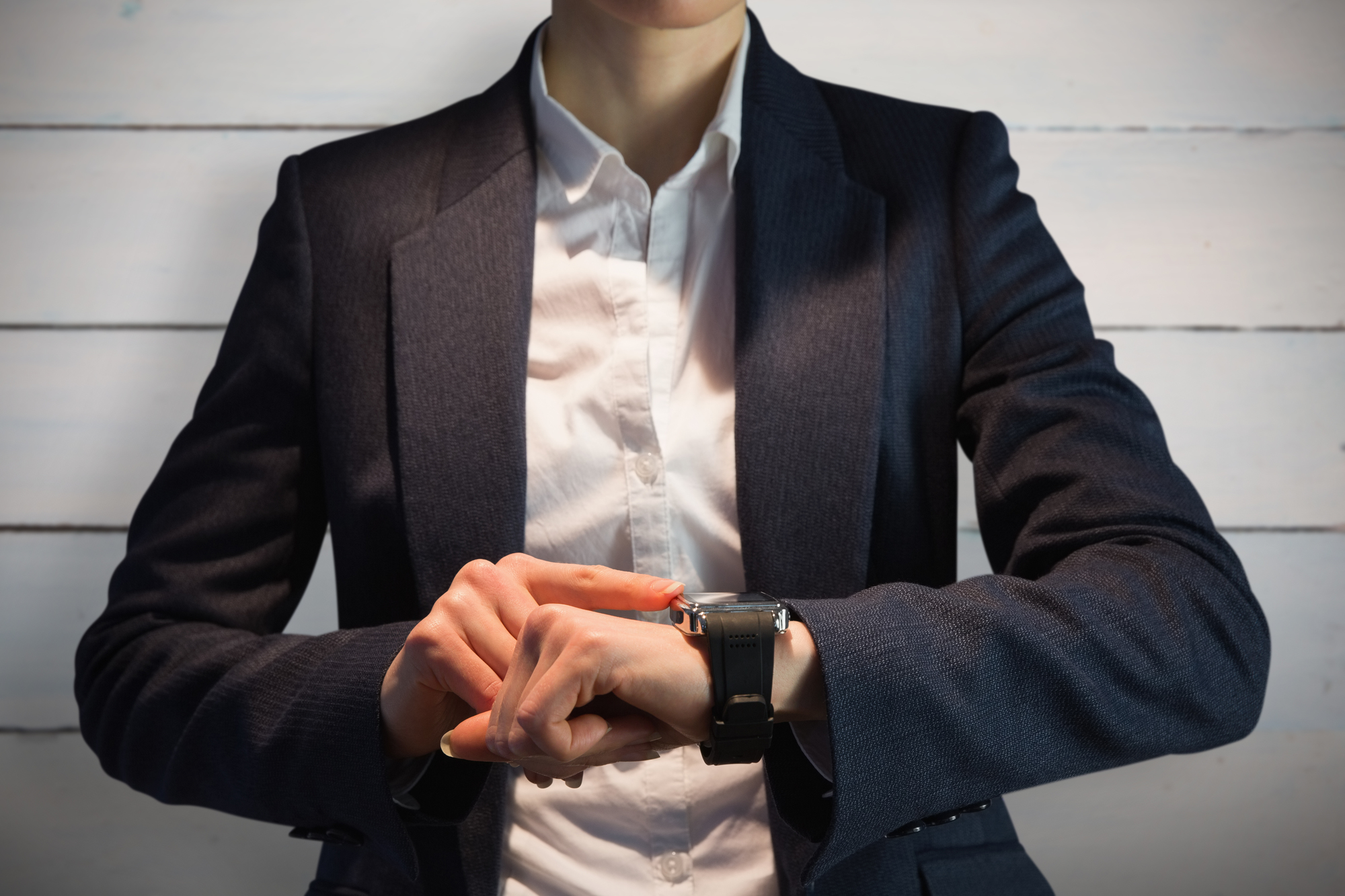 Businesswoman using watch against painted blue wooden planks