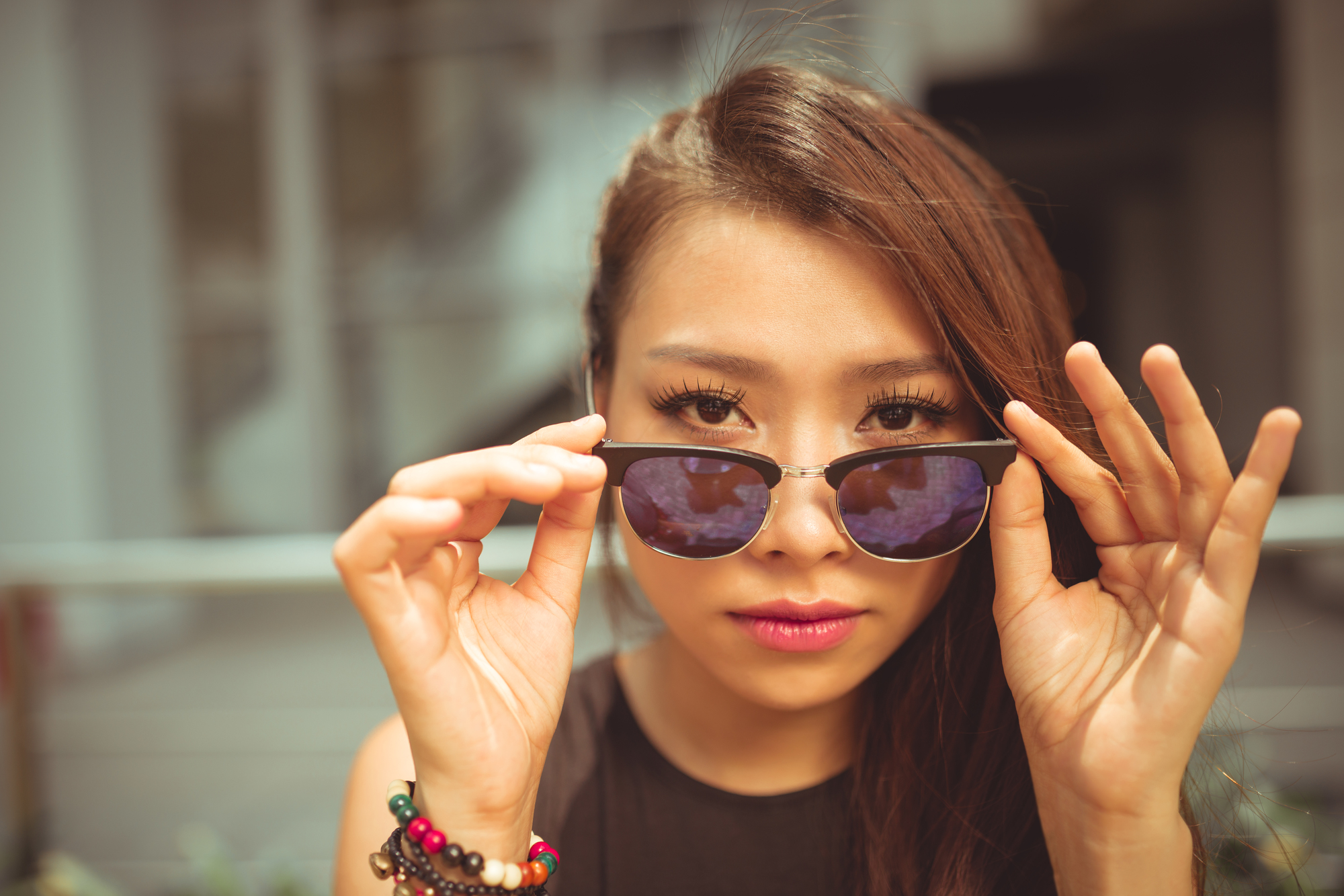 Beautiful Vietnamese woman with sunglasses looking at camera