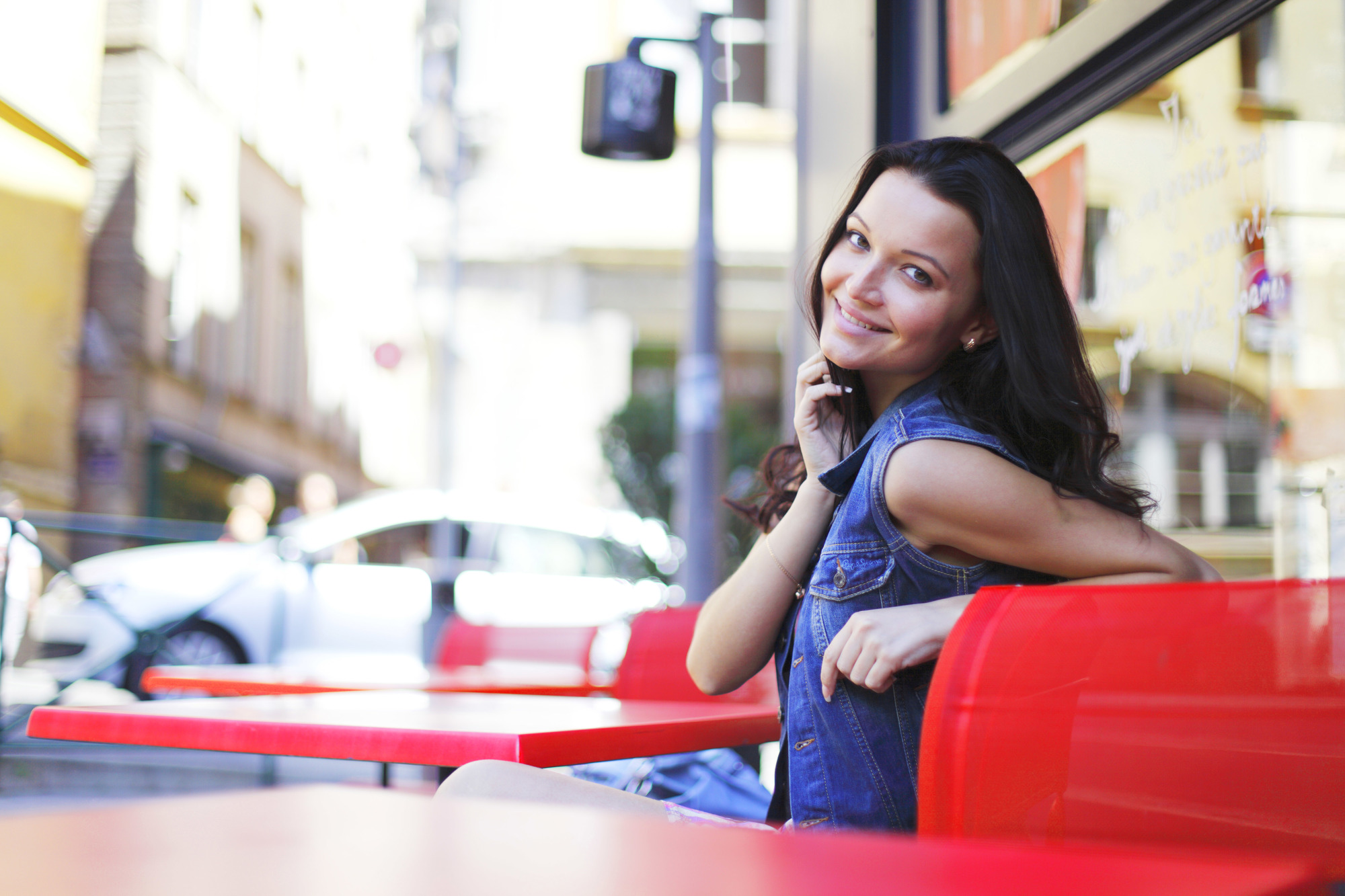beautiful young woman sitting alone in street cafe