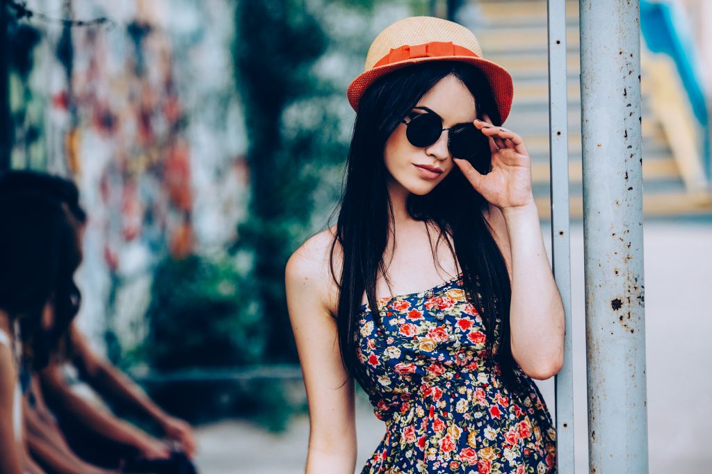beautiful girl in sunglasses posing for the camera in the city