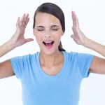 Stressed woman raising her hands around her head on white background