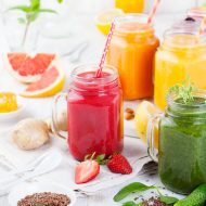 Smoothies, juices, beverages, drinks variety with fresh fruits and berries on a white wooden background.